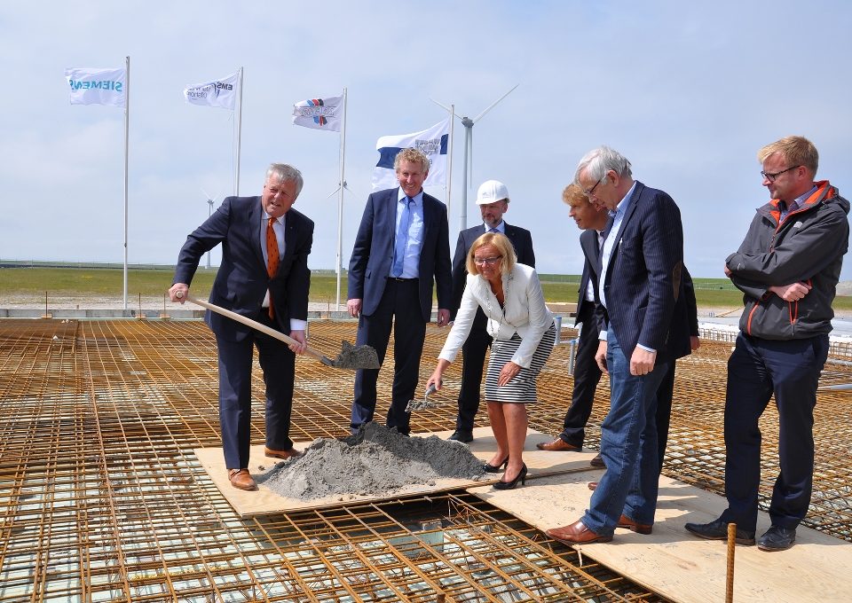 De buis gaat het fundament in: Groningen Seaports directeur Harm Post, EMO-directeur Knut Gerdes, EMO-projectleider Michael Baumfalk, de burgemeester van Eemsmond, Marijke van Beek, AG EMS-directeur Bernhard Brons, aannemer Jaap Kooi en Siemens projectmanager Gerard van Rijn.