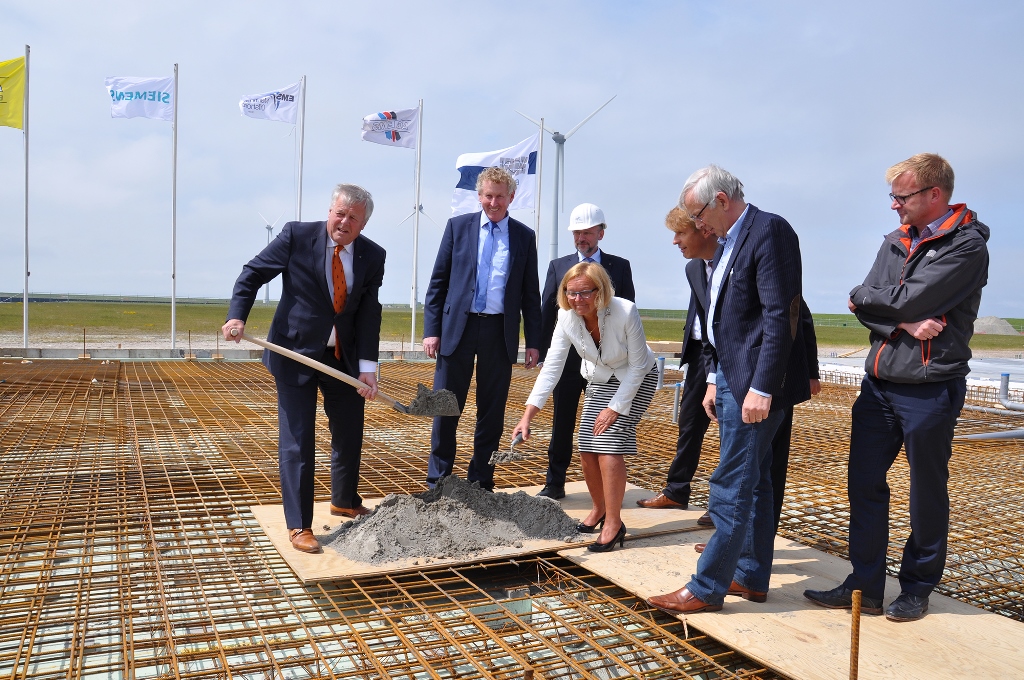 De buis gaat het fundament in: Groningen Seaports directeur Harm Post, EMO-directeur Knut Gerdes, EMO-projectleider Michael Baumfalk, de burgemeester van Eemsmond, Marijke van Beek, AG EMS-directeur Bernhard Brons, aannemer Jaap Kooi en Siemens projectmanager Gerard van Rijn.