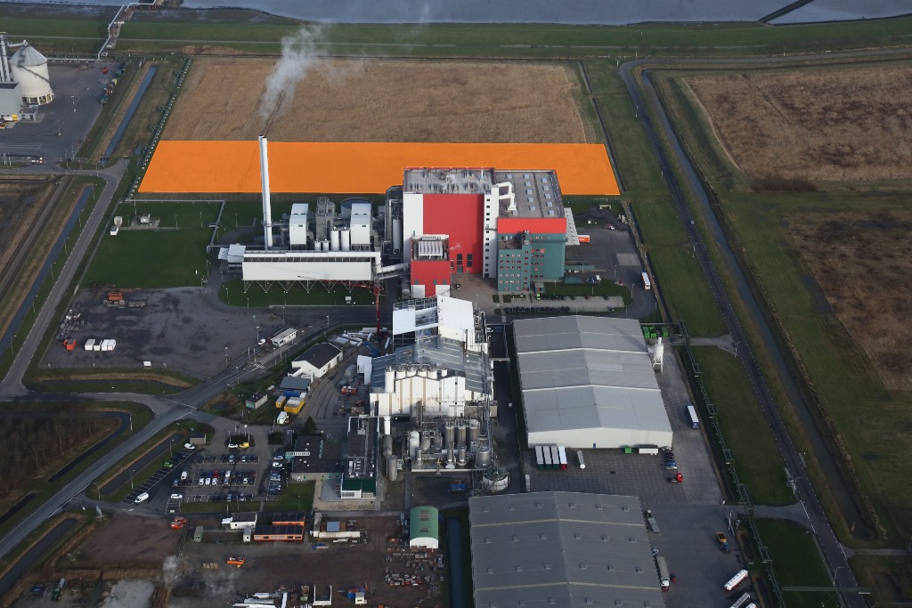 De afvalenergiecentrale EEW Energy from Waste (rode fabriek) met daarachter het uitbreidingsgebied (oranje vlak)