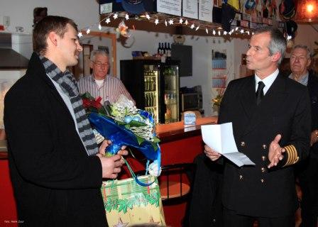 Havenmeester André Bruijn (r) zet de 10.000ste zeeman die een bezoek bracht aan het Zeemanshuis in de Eemshaven in het zonnetje (foto Henk Zuur, Wagenborg)